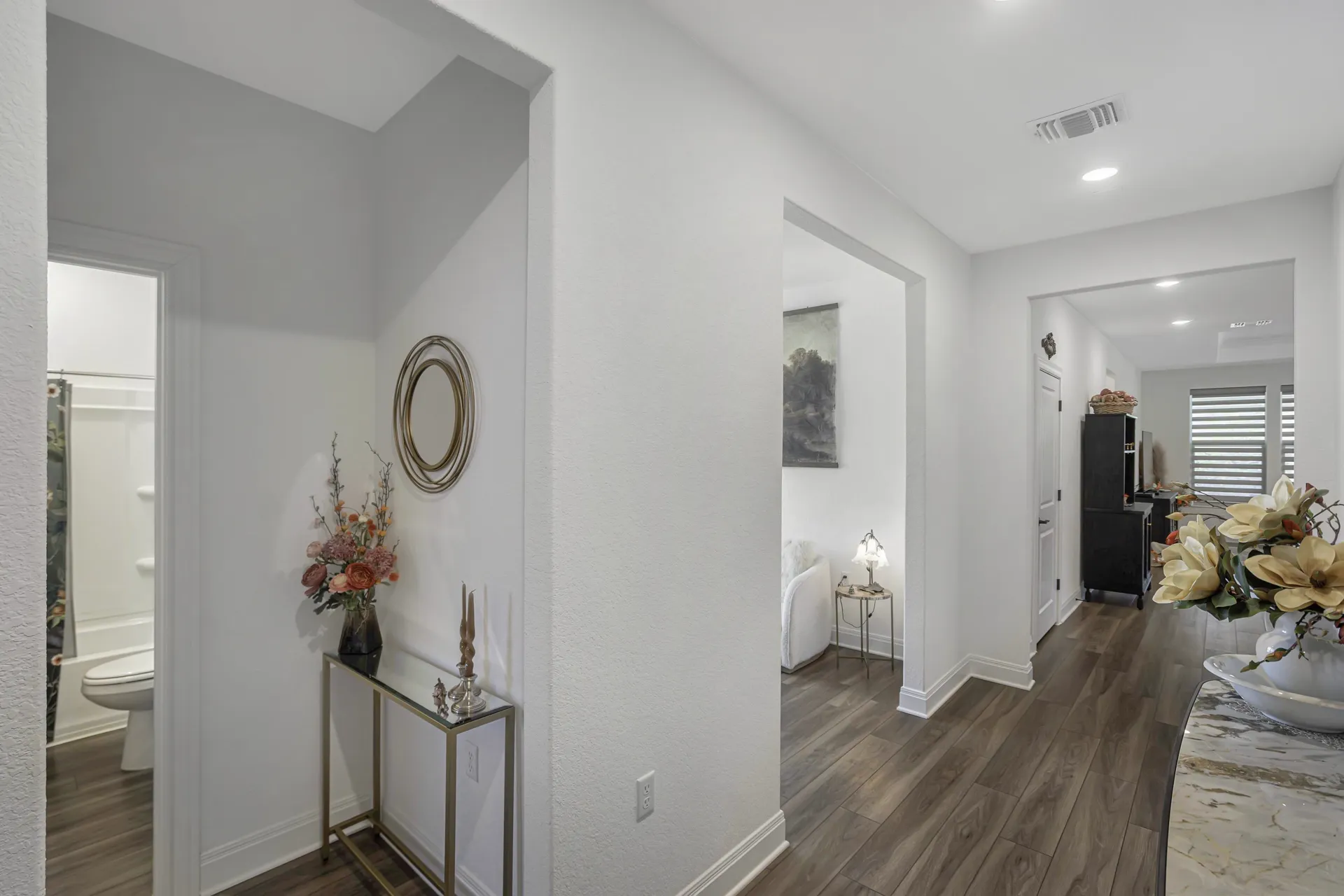 Hallway with ceiling fan, white walls and clean design