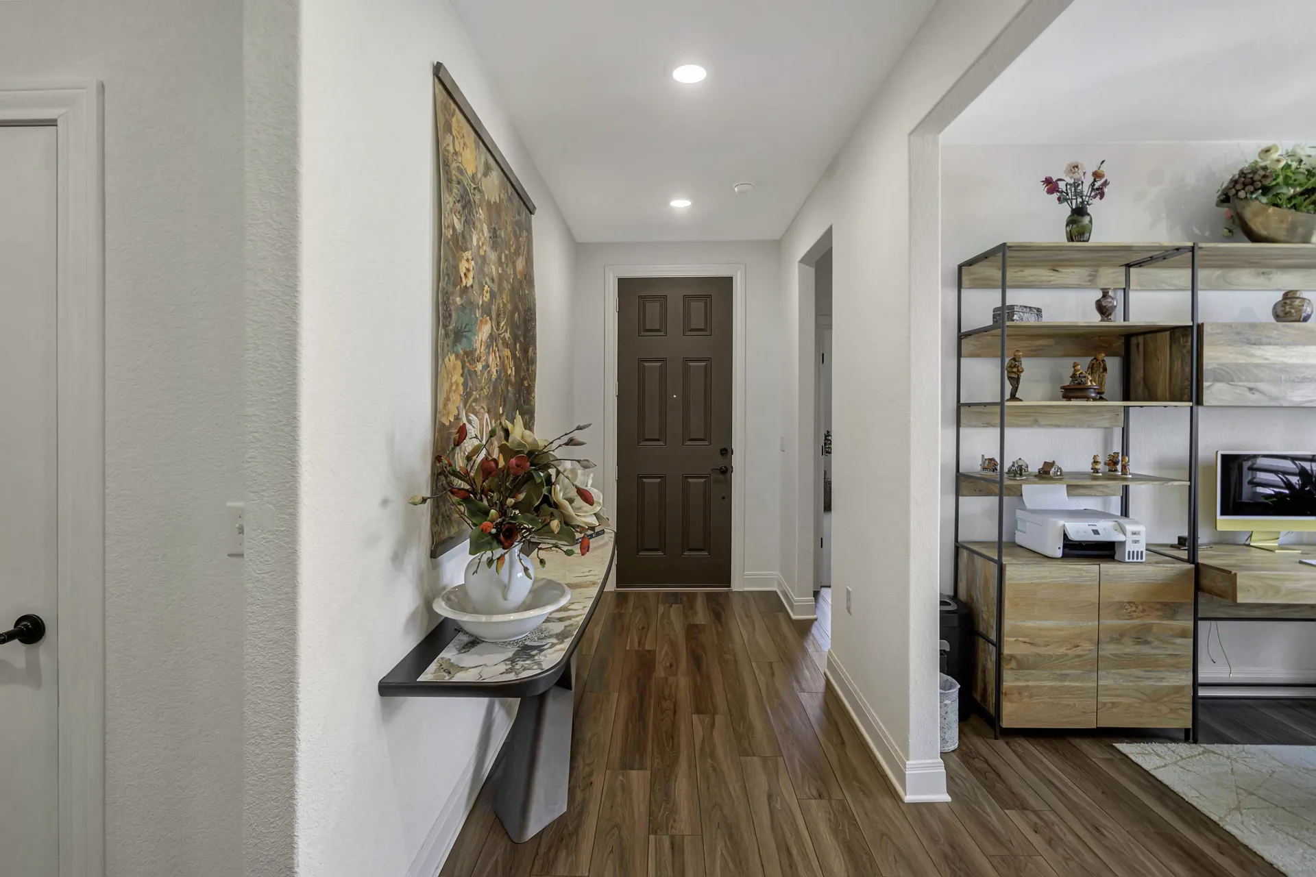 Entry foyer with tapestry, console table and front door view