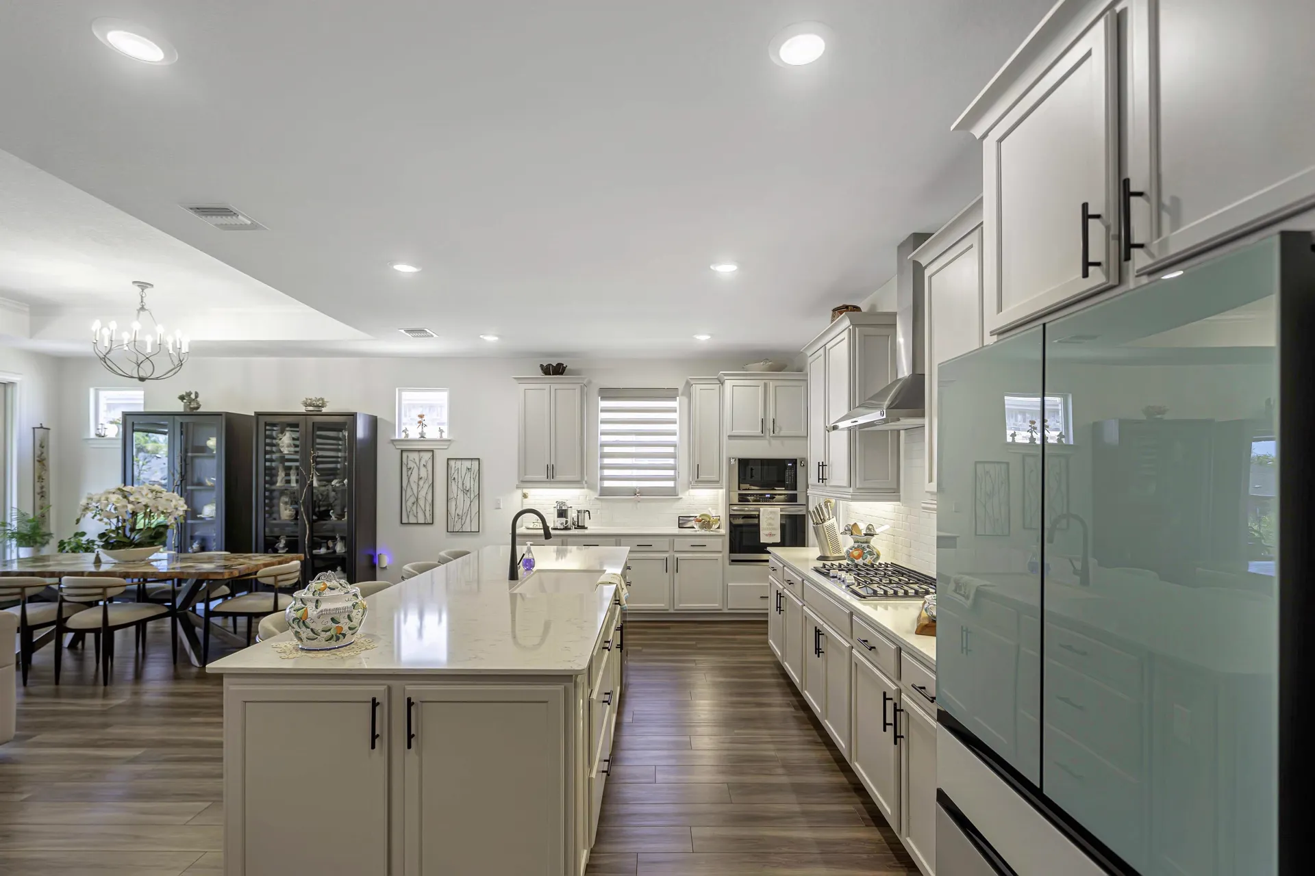 Open-concept kitchen and living — wide view with hardwood floors