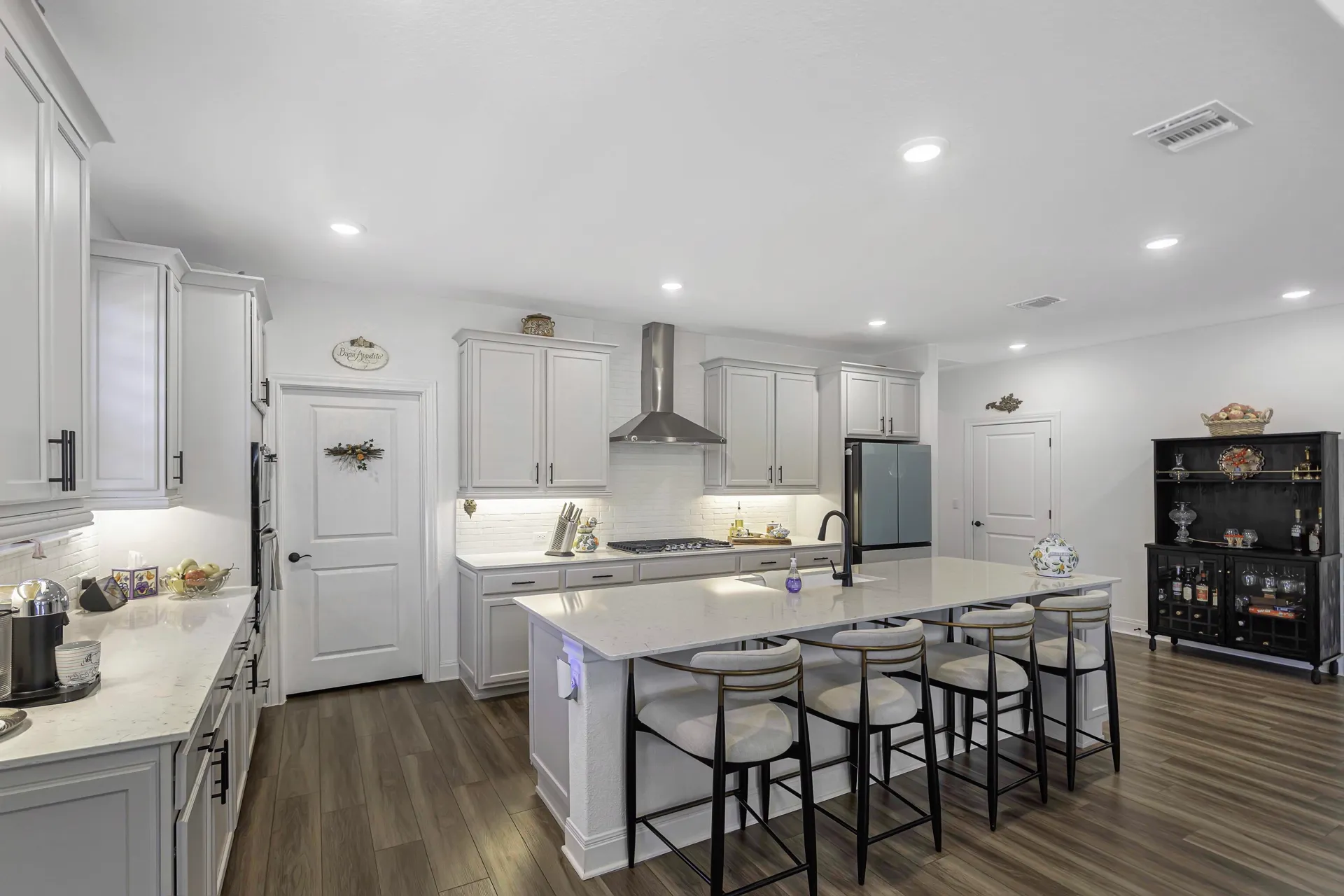 Kitchen island with bar stools, pendant lights and open to living area
