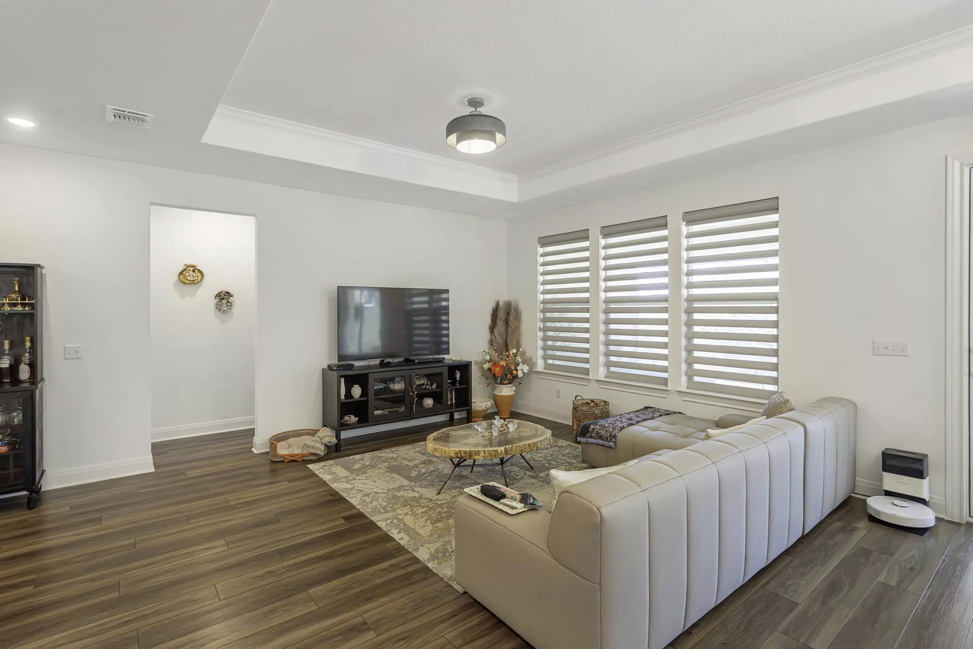 Living room with sectional sofa, hardwood floors and plantation shutters