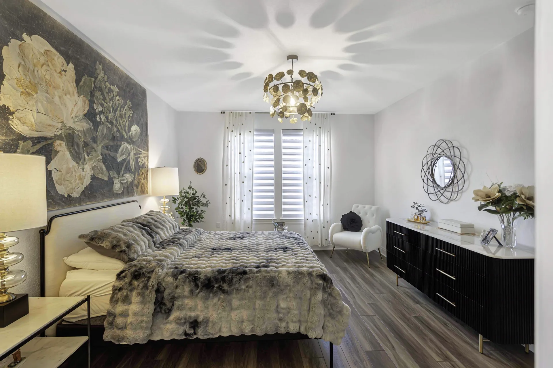 Primary bedroom wide view with tray ceiling and plantation shutters