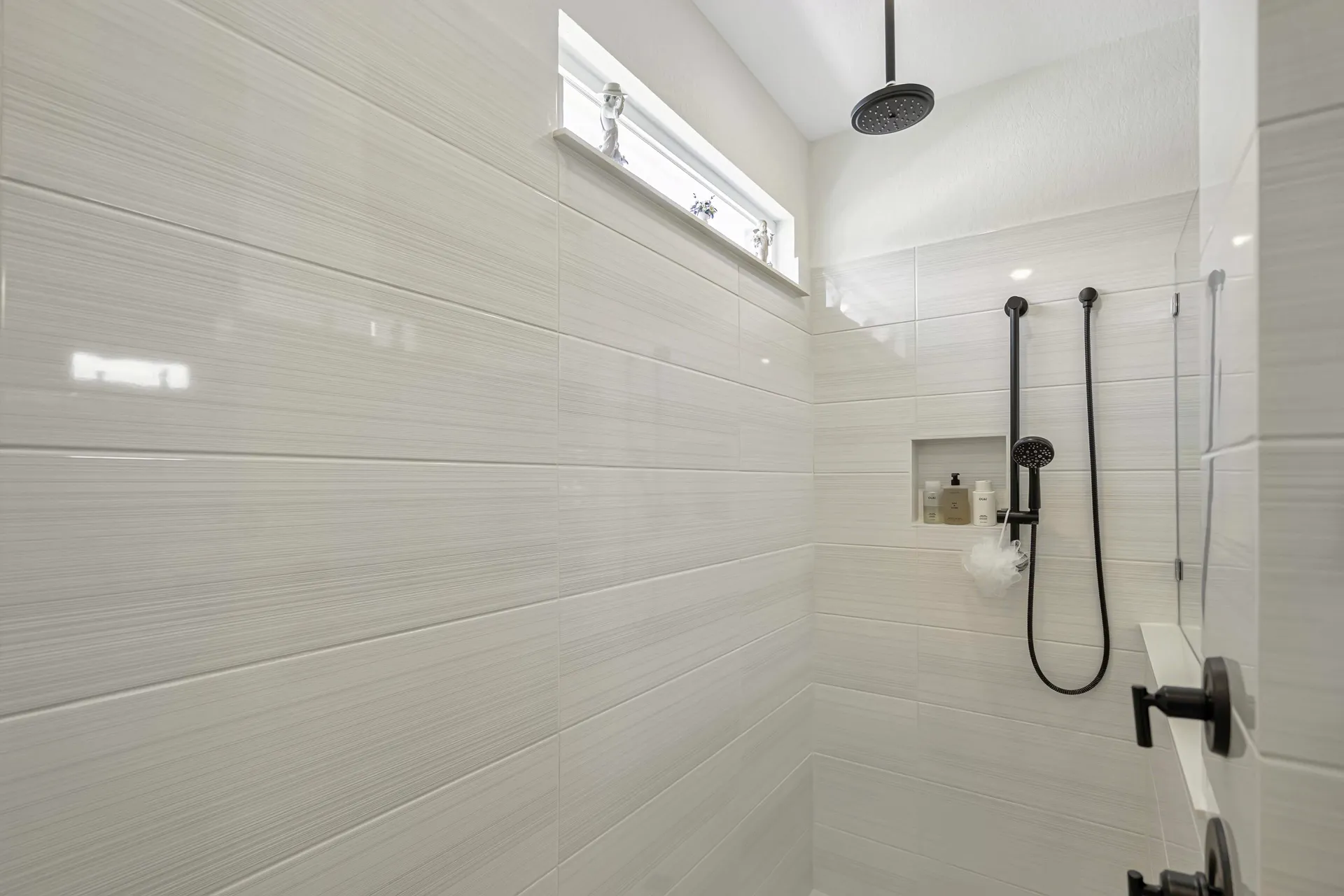 Primary bathroom vanity close-up with fresh flowers and black fixtures