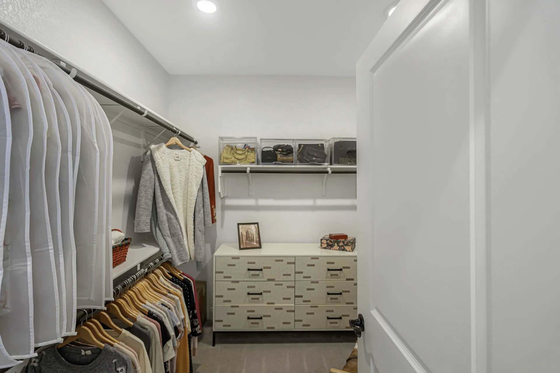 Primary walk-in closet with built-in drawers and hanging space